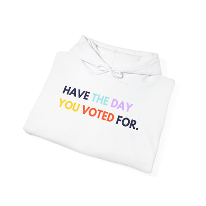 White hoodie with colorful text 'HAVE THE DAY YOU VOTED FOR.' on a white background